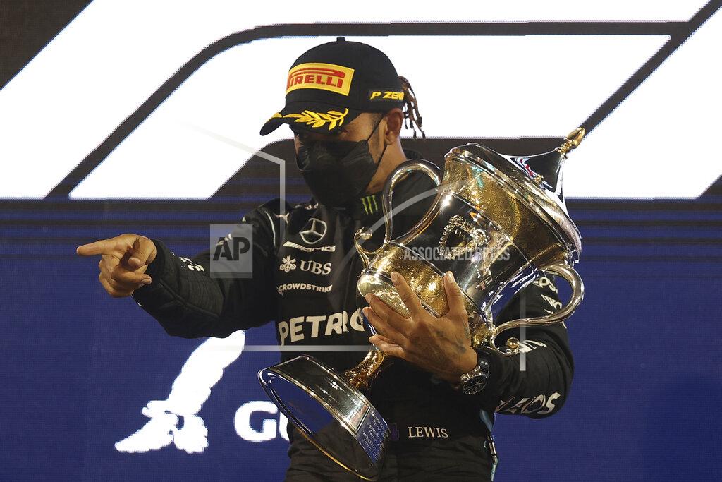 Lars Baron Mercedes driver Lewis Hamilton of Britain celebrates on the podium after winning the Bahrain Formula One Grand Prix at the Bahrain International Circuit in Sakhir, Bahrain, Sunday, March 28, 2021. (Lars Baron, Pool via AP)
