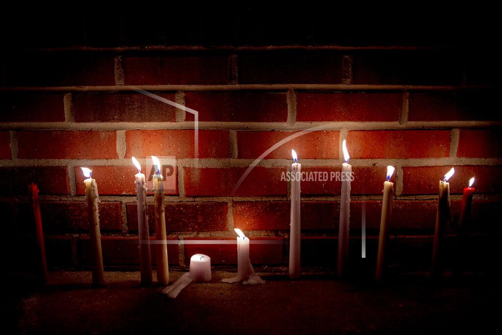 Jake May Candles are left lit next to a wall of a Family Dollar store to honor Calvin Munerlyn on Sunday, May 3, 2020, in Flint, Mich. Munerlyn was shot and killed Friday at a Family Dollar store in Flint. He'd worked at the store as a security guard for a little more than one year. (Jake May/The Flint Journal via AP)