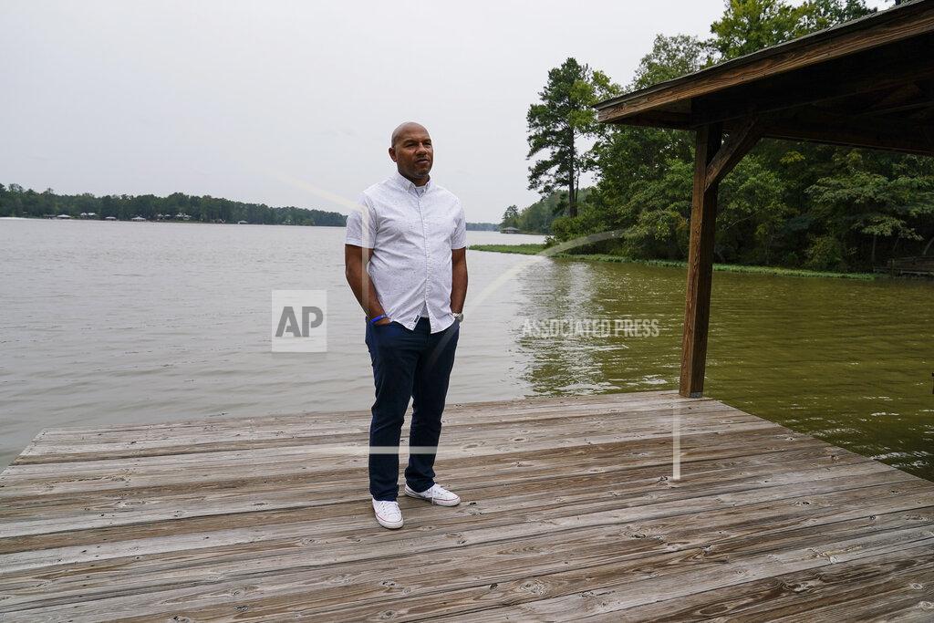 Brynn Anderson Hancock County coroner Adrick Ingram, 44, of Sparta, poses for a portrait on a deck next to a lake, Saturday, Sept. 19, 2020, in Sparta, Ga. The number of COVID-19 deaths in Hancock County is the highest per-capita rate of any U.S. county. ''It has affected our community in a way that I consider tragic," Ingram says. (AP Photo/Brynn Anderson)