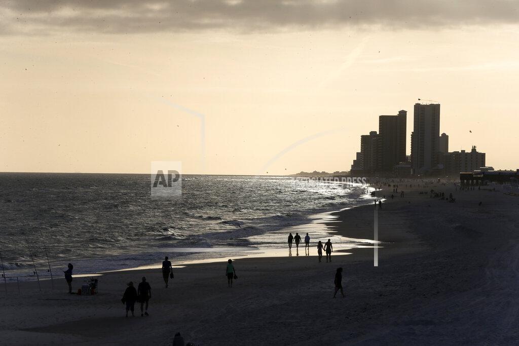 Gerald Herbert In this March 12, 2020, photo, people walk on the beach in Orange Beach, Ala. As oil spewed into the Gulf of Mexico from a blown-out BP well in 2010, residents wondered whether their home would ever be the same. The Deepwater Horizon disaster changed the region, with a flood of spending altering landscapes and attitudes. (AP Photo/Gerald Herbert)