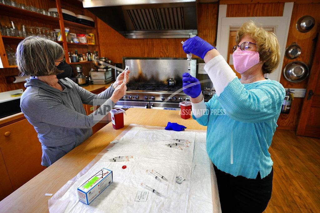 Robert F. Bukaty Nurses Sharon Daley, left, and Maureen Giffen fill syringes with the Moderna COVID-19 vaccine in a makeshift clinic in the kitchen of a community center, Friday, March 19, 2021, on Great Cranberry Island, Maine. (AP Photo/Robert F. Bukaty)