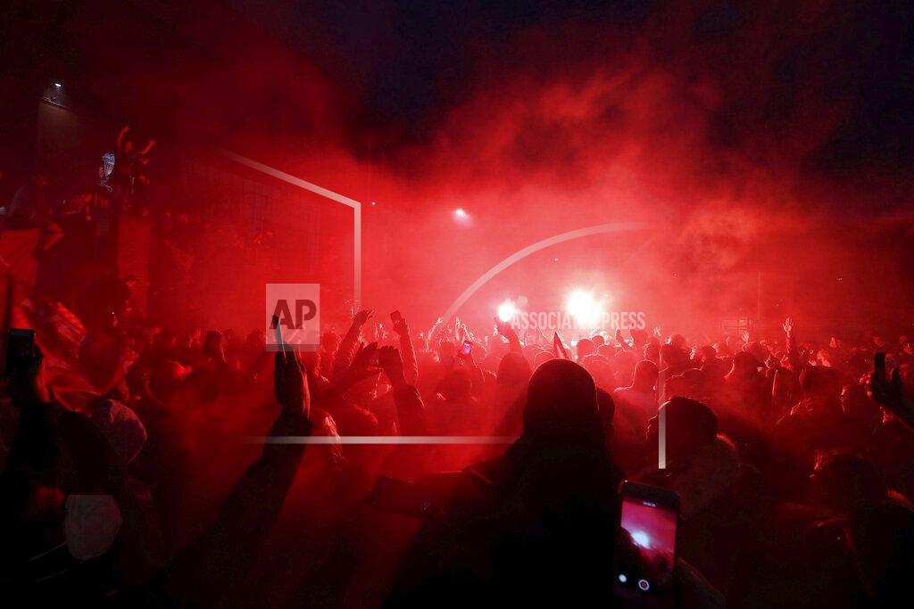 Martin Rickett Liverpool fans celebrate outside Anfield stadium after the English Premier soccer match between Liverpool and Chelsea, Wednesday, July 22, 2020, in Liverpool, England. (Martin Rickett/PA via AP)