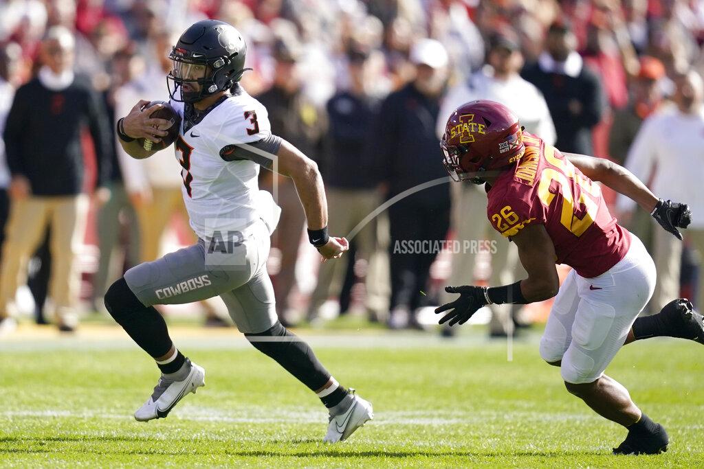 Charlie Neibergall Oklahoma State quarterback Spencer Sanders (3) runs from Iowa State defensive back Anthony Johnson Jr. (26) during the first half of an NCAA college football game, Saturday, Oct. 23, 2021, in Ames, Iowa. (AP Photo/Charlie Neibergall)