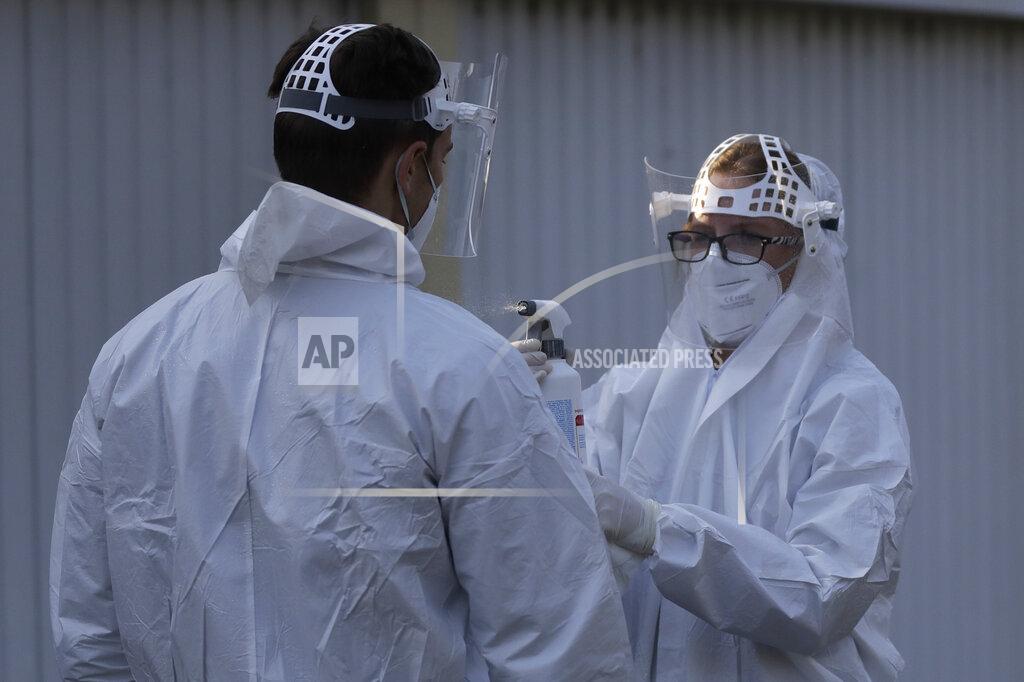 Petr David Josek A healthcare worker has his protective suit disinfected at a sampling station for COVID-19 in Prague, Czech Republic, Monday, Sept. 21, 2020. The country coped well with the first wave of the coronavirus infections in the spring but has been facing a record surge of the new confirmed cases last week. (AP Photo/Petr David Josek)