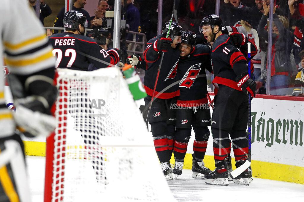 Karl B Deblaker Carolina Hurricanes' Max Domi (13) celebrates hiss goal against the Boston Bruins with Brady Skjei, left, and Jordan Staal (11) during the second period of Game 7 of an NHL hockey Stanley Cup first-round playoff series in Raleigh, N.C., Saturday, May 14, 2022. (AP Photo/Karl B DeBlaker)