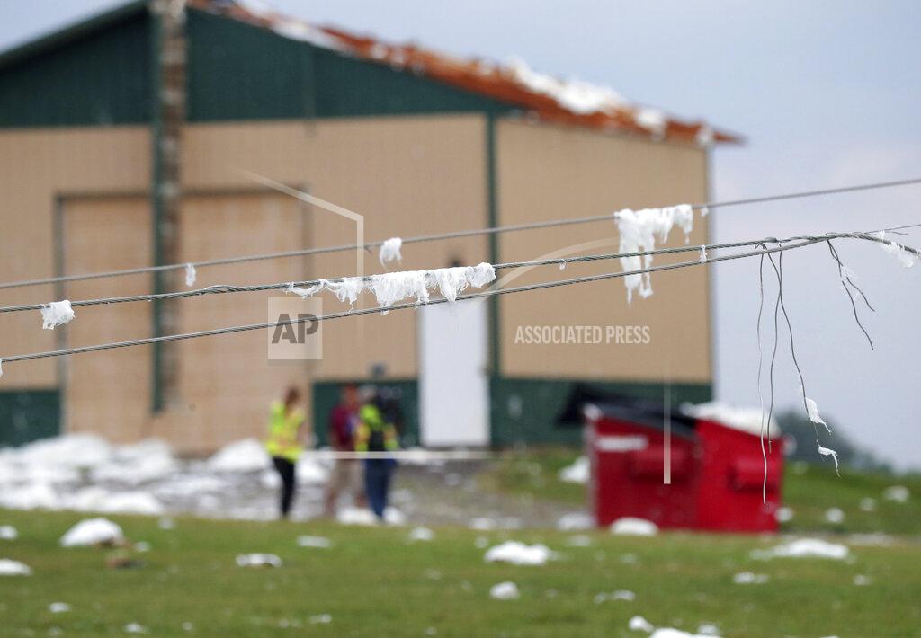 Mike De Sisti Insulations covers power lines at D and D Well and Pumps where a roof was torn off a storage shed on County Highway F in the Town of Concord, Wis., on Thursday, July 29, 2021. A line of thunderstorms arrived early Thursday generating numerous tornado warnings as well as high winds and near-constant lightning. (Mike De Sisti/Milwaukee Journal-Sentinel via AP)