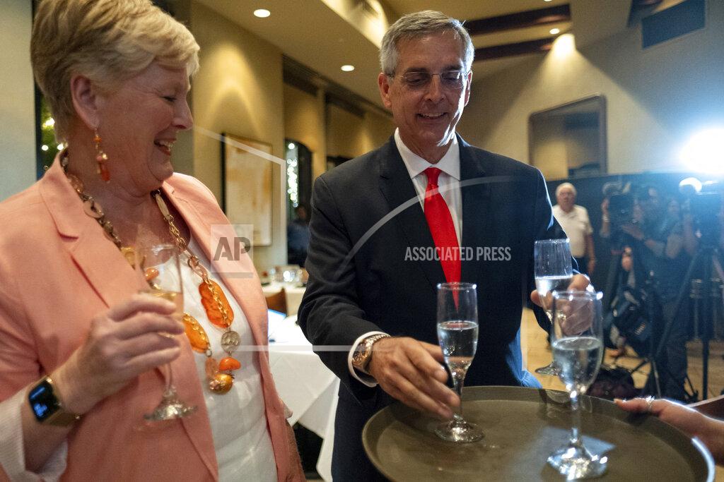 Ben Gray Incumbent Georgia Secretary of State Brad Raffensperger, grabs a glass of champagne to toast with his wife Tricia after declaring victory just before midnight at an election night party Tuesday evening, May 24, 2022 at a small restaurant in Peachtree Corners, Ga. (AP Photo/Ben Gray)