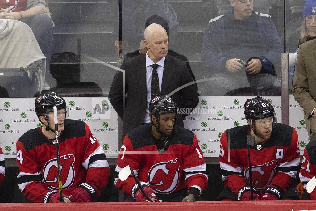New Jersey Devils coach John Hynes, center, watches the team play the New York Rangers during the third period of a preseason NHL hockey game Friday, Sept. 20, 2019, in Newark, N.J. (AP Photo/Mary Altaffer)