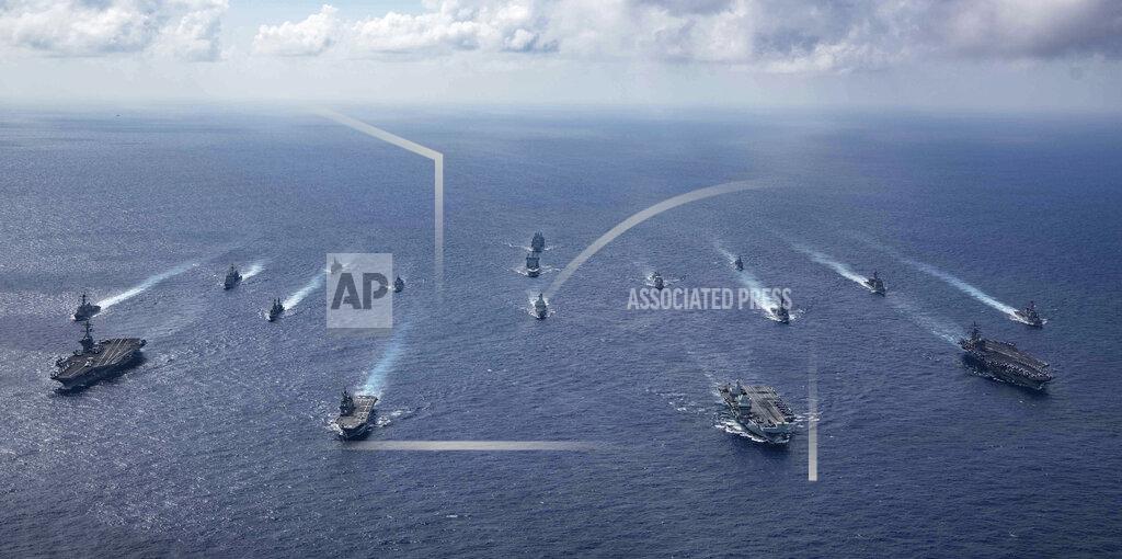 Jason Tarleton In this photo released by the U.S. Indo-Pacific Command, the United Kingdom's carrier strike group led by HMS Queen Elizabeth (R 08), and Japan Maritime Self-Defense Forces led by (JMSDF) Hyuga-class helicopter destroyer JS Ise (DDH 182) joined with U.S. Navy carrier strike groups led by flagships USS Ronald Reagan (CVN 76) and USS Carl Vinson (CVN 70) sails to conduct multiple carrier strike group operations in the Philippine Sea, on Oct. 3, 2021. After sending a record number of military aircraft to harass Taiwan over China’s National Day holiday weekend, Beijing has toned down the sabre rattling but tensions remain high, with the rhetoric and reasoning behind the exercises unchanged. (Jason Tarleton/U.S. Navy via AP)