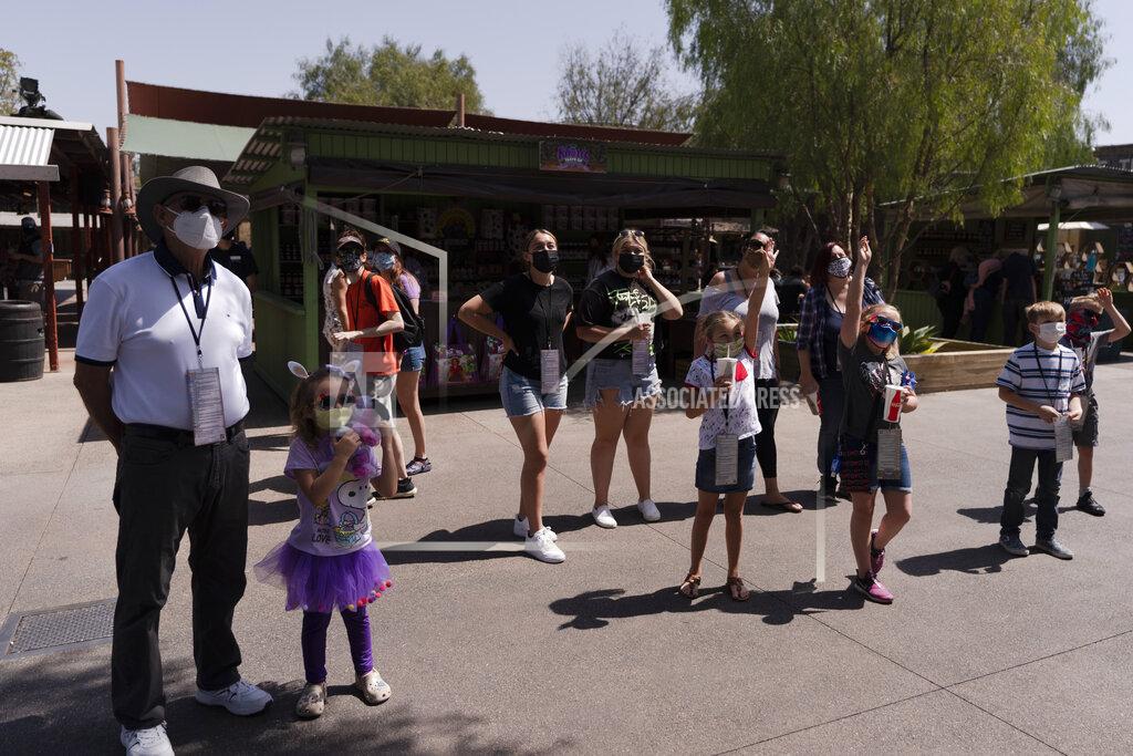 Jae C. Hong People interact with a performer during the Knott's Taste of Boysenberry Festival at Knott's Berry Farm in Buena Park, Calif., Tuesday, March 30, 2021. Massive Los Angeles County can reopen even more businesses, California public health officials announced Tuesday. The county of 10 million people was one of several counties, including neighboring Orange County, that moved into the state's second-least restrictive orange tier amid low coronavirus case rates. (AP Photo/Jae C. Hong)