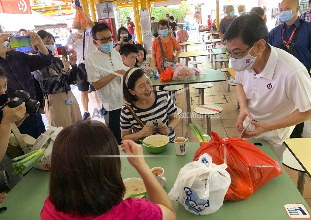 Heng Swee Keat, Singapore Deputy Prime Minister and First Assistant Secretary-General of the People’s Action Party, wears a face mask while speaking to residents at the Bedok South market during the final day of the election campaign Wednesday, July 8, 2020, in Singapore. Singaporeans go to the polls on July 10, 2020, in Southeast Asia's first election since the coronavirus pandemic began, with the health crisis and an economic recession expected to bolster Prime Minister Lee Hsien Loong's party and extend its unbroken rule. (AP Photo/Royston Chan)