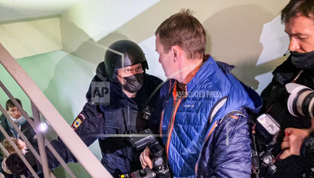 Mstyslav Chernov A police officer pushes photographers from a door of the apartment where Oleg Navalny, brother of jailed opposition leader Alexei Navalny lives in Moscow, Russia, Wednesday, Jan. 27, 2021. Police are searching the Moscow apartment of jailed Russian opposition leader Alexei Navalny, another apartment where his wife is living and two offices of his anti-corruption organization. Navalny's aides reported the Wednesday raids on social media. (AP Photo/Mstyslav Chernov)