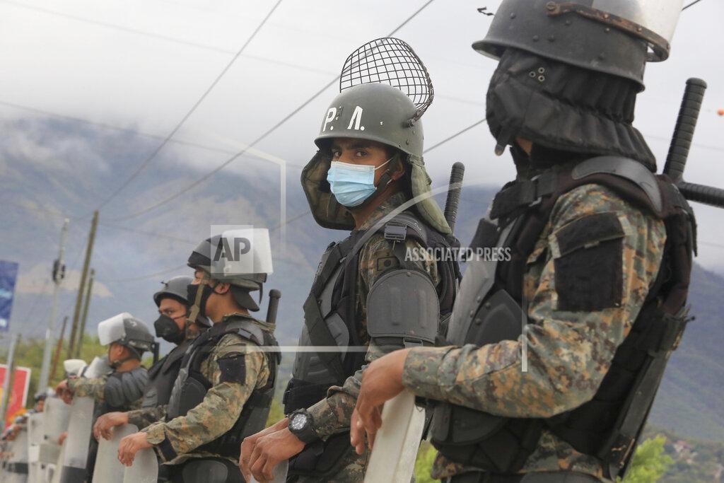 Guatemalan soldiers stands guard at a police checkpoint on the Motagua River to stop the advance of Honduran migrants in Zacapa, Guatemala, Tuesday, Jan. 19, 2021. A once large caravan of Honduran migrants that pushed its way into Guatemala last week had dissipated by Tuesday in the face of Guatemalan security forces. (AP Photo/Oliver de Ros)