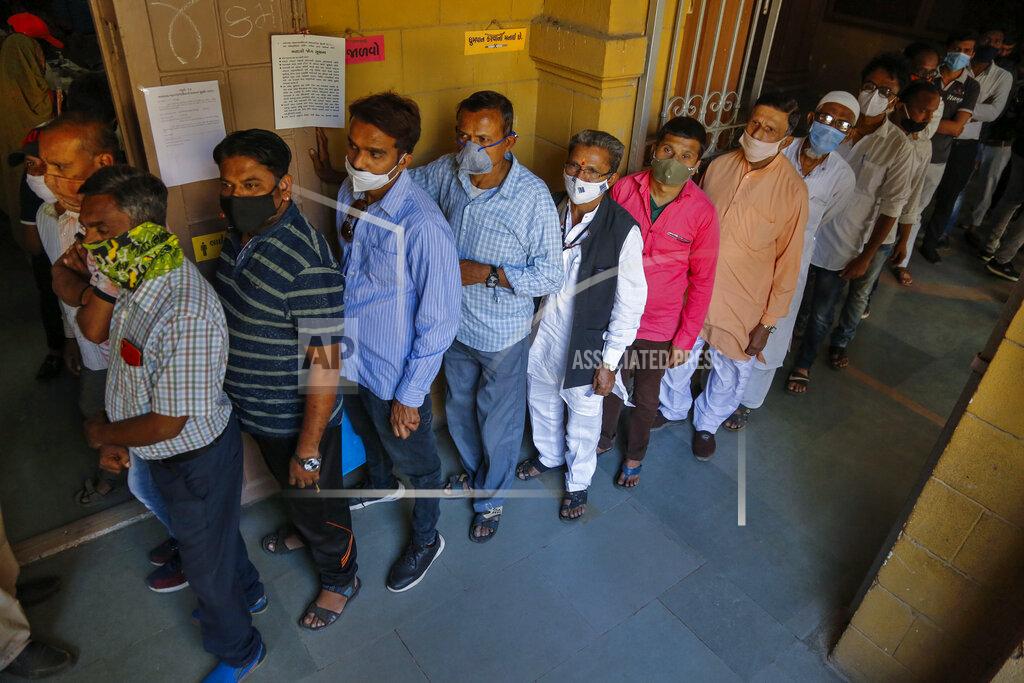 Ajit Solanki Indians wearing face masks as precaution against COVID-19, stand in queue to cast their vote for local body elections in Ahmedabad, India, Sunday, Feb. 21, 2021. (AP Photo/Ajit Solanki)