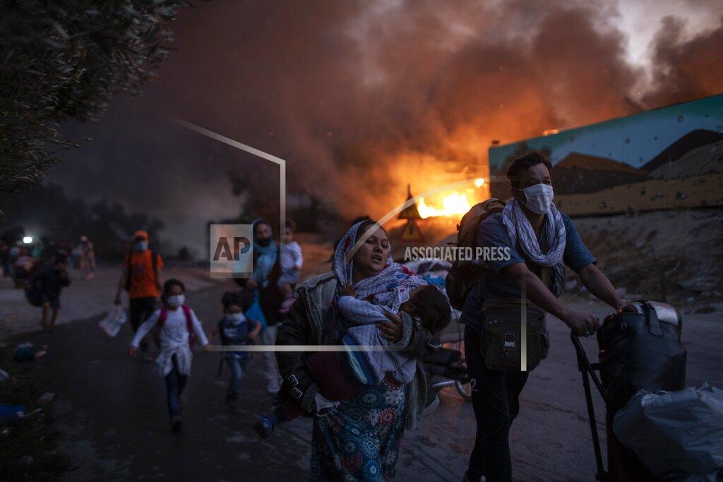 Petros Giannakouris FILE - In this Wednesday, Sept. 9, 2020 file photo, migrants flee from the Moria refugee camp during a second fire, on the northeastern Aegean island of Lesbos, Greece. Five years on, the deal between European Union and Turkey is no longer working but at a summit next week EU leaders will discuss ways to improve relations with Turkey and could try to revive the agreement. (AP Photo/Petros Giannakouris, File)