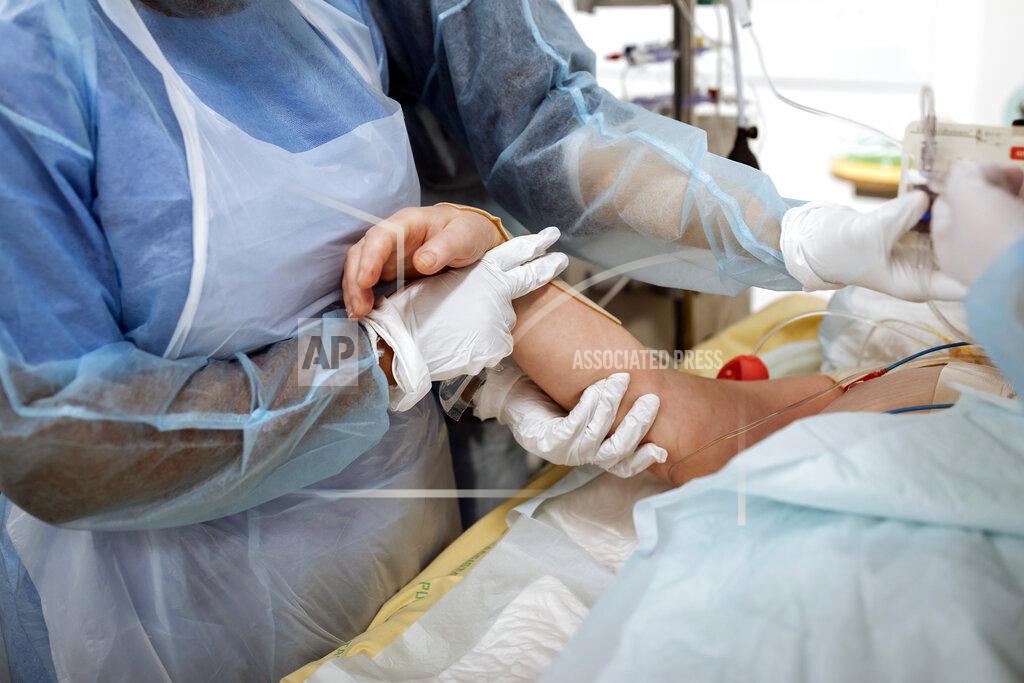 Lewis Joly Nurse Yvana Faro holds a patient's hand inside an operating room now used for unconscious COVID-19 patients at Bichat Hospital, AP-HP, in Paris, Thursday, April 22, 2021. France still had nearly 6,000 critically ill patients in ICUs this week as the government embarked on the perilous process of gingerly easing the country out of its latest lockdown, too prematurely for those on pandemic frontlines in hospitals. President Emmanuel Macron's decision to reopen elementary schools on Monday and allow people to move about more freely again in May, even though ICU numbers have remained stubbornly higher than at any point since the pandemic's catastrophic first wave, marks another shift in multiple European capitals away from prioritizing hospitals. (AP Photo/Lewis Joly)