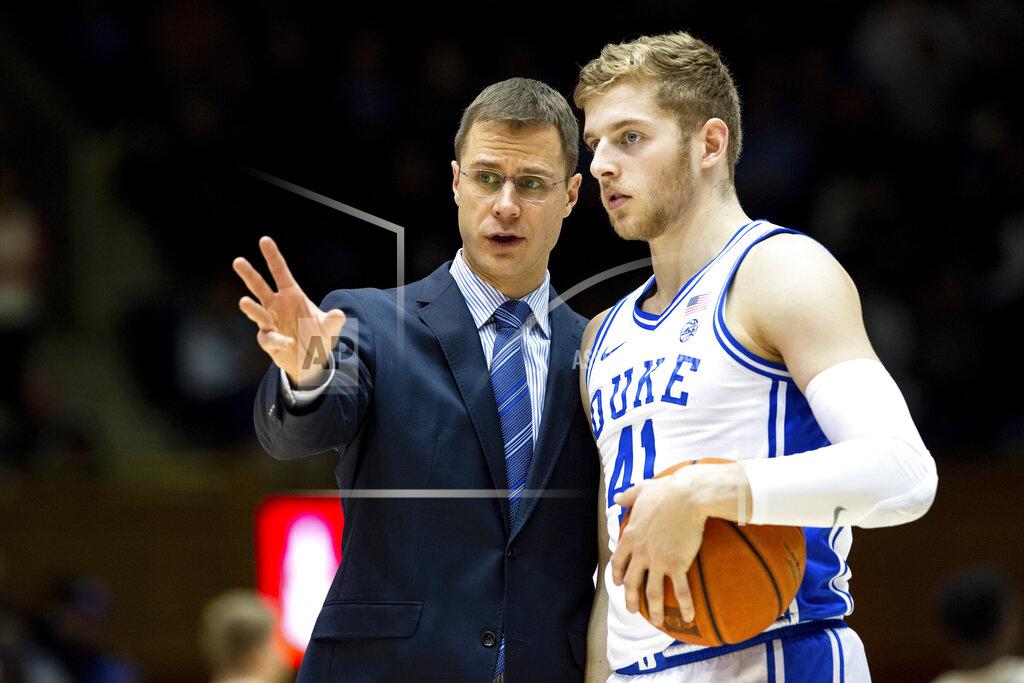 Ben Mckeown FILE - In this Dec. 19, 2019, file photo, Duke associate head coach Jon Scheyer, left, speaks with Jack White (41) during an NCAA college basketball game against Wofford in Durham, N.C. Duke Hall of Fame coach Mike Krzyzewski will coach his final season with the Blue Devils in 2021-22, a person familiar with the situation said Wednesday, June 2, 2021. The person said former Duke player and associate head coach Jon Scheyer would then take over as Krzyzewski's successor for the 2022-23 season. (AP Photo/Ben McKeown, File)