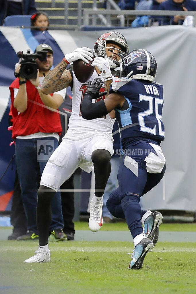 Tampa Bay Buccaneers wide receiver Mike Evans, left, scores a touchdown against Tennessee Titans cornerback Logan Ryan (26) on a 2-yard pass play in the second half of an NFL football game Sunday, Oct. 27, 2019, in Nashville, Tenn.(AP Photo/James Kenney)