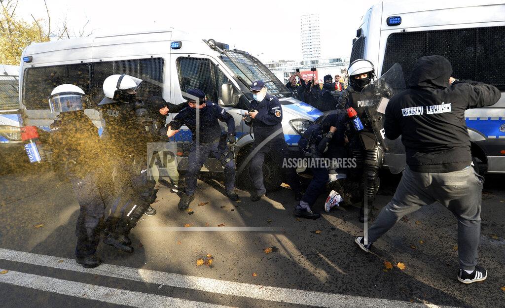 Czarek Sokolowski Polish police aim tear gas cannisters at protesters angry over new restrictions aimed at fighting the coronavirus pandemic, in Warsaw, Poland, Saturday, Oct. 24, 2020. The protesters included entrepreneurs, far-right politicians, football fans and vaccine opponents. The protesters, many wearing no protective masks, violated a new restriction on gatherings of more people. The clashes come amid rising social tensions and as new restrictions just short of a full lockdown took effect Saturday. (AP Photo/Czarek Sokolowski)