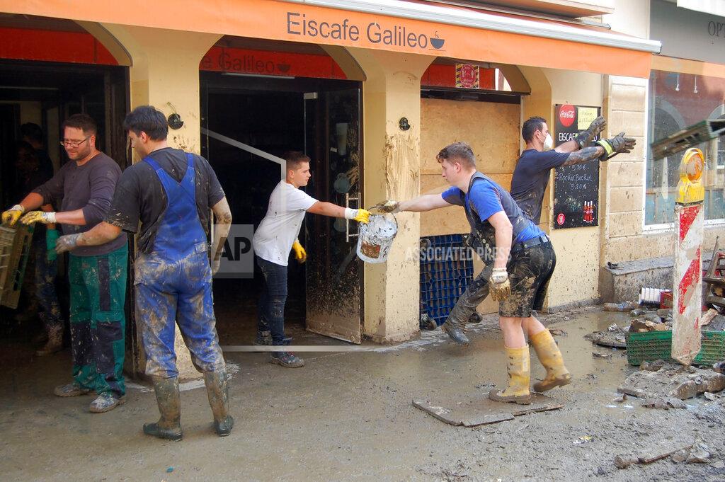 Frank Jordans Volunteers form a human chain to carry debris from a restaurant onto a street in the flood-hit town of Ahrweiler, Germany, on Friday, July 23, 2021. With the death toll and economic damage from last week’s floods in Germany continuing to rise, questions have been raised about why systems designed to warn people of the impending disaster didn’t work. (AP Photo/Frank Jordans)