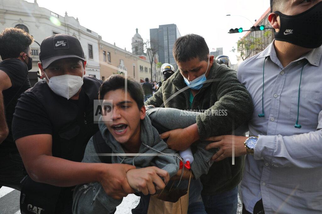 Rodrigo Abd Plainclothes policemen detain a supporter of ousted President Martin Vizcarra near a police barricade, preventing marchers who are refusing to recognize the new government from reaching Congress, in Lima, Peru, Wednesday, Nov. 11, 2020. On Tuesday, Peru swore in Manuel Merino as president, after Peru’s legislature booted Vizcarra from office on Monday. (AP Photo/Rodrigo Abd)