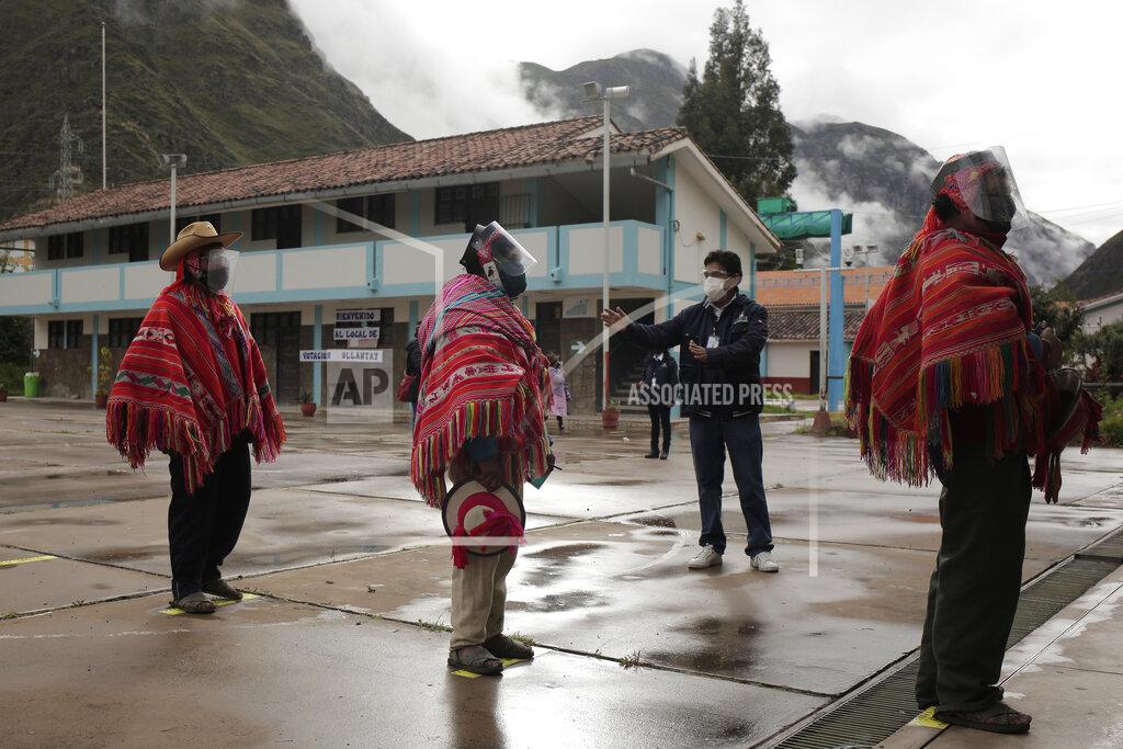 Sharon Castellanos An electoral official instructs voters to keep social distance to prevent the spread of the new coronavirus during general elections in Ollantaytambo, Peru, Sunday, April 11, 2021. (AP Photo/Sharon Castellanos)