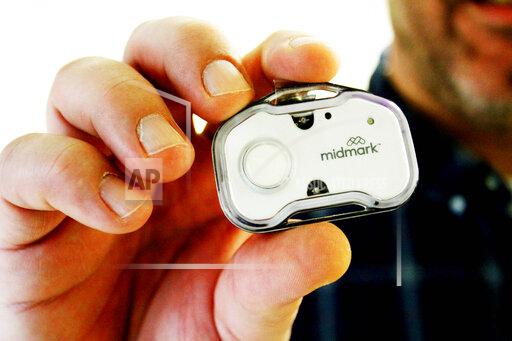 Keith Mathis holds a panic button he helped create as part of CoxHealth's Innovation Accelerators program. Nurses and hundreds of other staff members will soon begin wearing panic buttons at a Missouri hospital where assaults on workers tripled after the onset of the COVID-19 pandemic. (Sara Karnes/The Springfield News-Leader via AP)