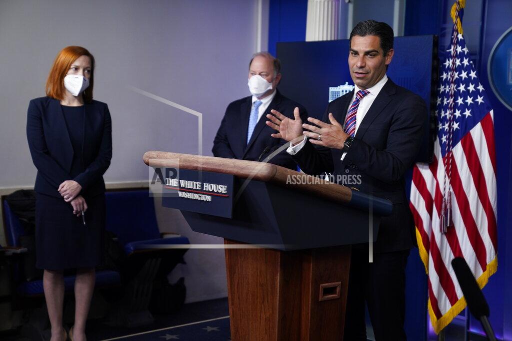 White House press secretary Jen Psaki, left, and Detroit mayor Mike Duggan, center, listen as Miami mayor Francis Suarez speaks during a press briefing at the White House, Friday, Feb. 12, 2021, in Washington. (AP Photo/Evan Vucci)