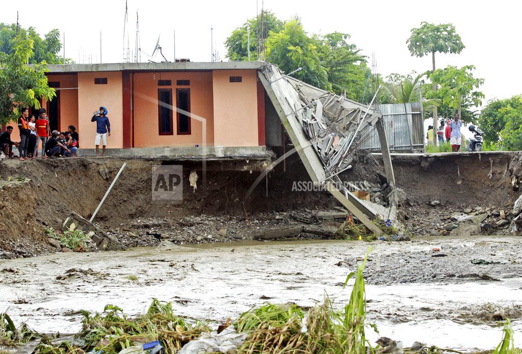 Kandhi Barnez People inspect buildings damaged by a flood in Dili, East Timor, Monday, April 5, 2021. Multiple disasters caused by torrential rains in eastern Indonesia and neighboring East Timor have left dozens of people dead and missing and displaced thousands. (AP Photo/Kandhi Barnez)