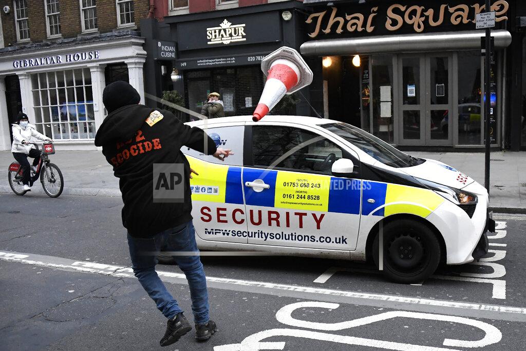 Alberto Pezzali A man throws a traffic cone at a car during clashes following a 'Kill the Bill' protest in London, Saturday, April 3, 2021. The demonstration is against the contentious Police, Crime, Sentencing and Courts Bill, which is currently going through Parliament and would give police stronger powers to restrict protests. (AP Photo/Alberto Pezzali)