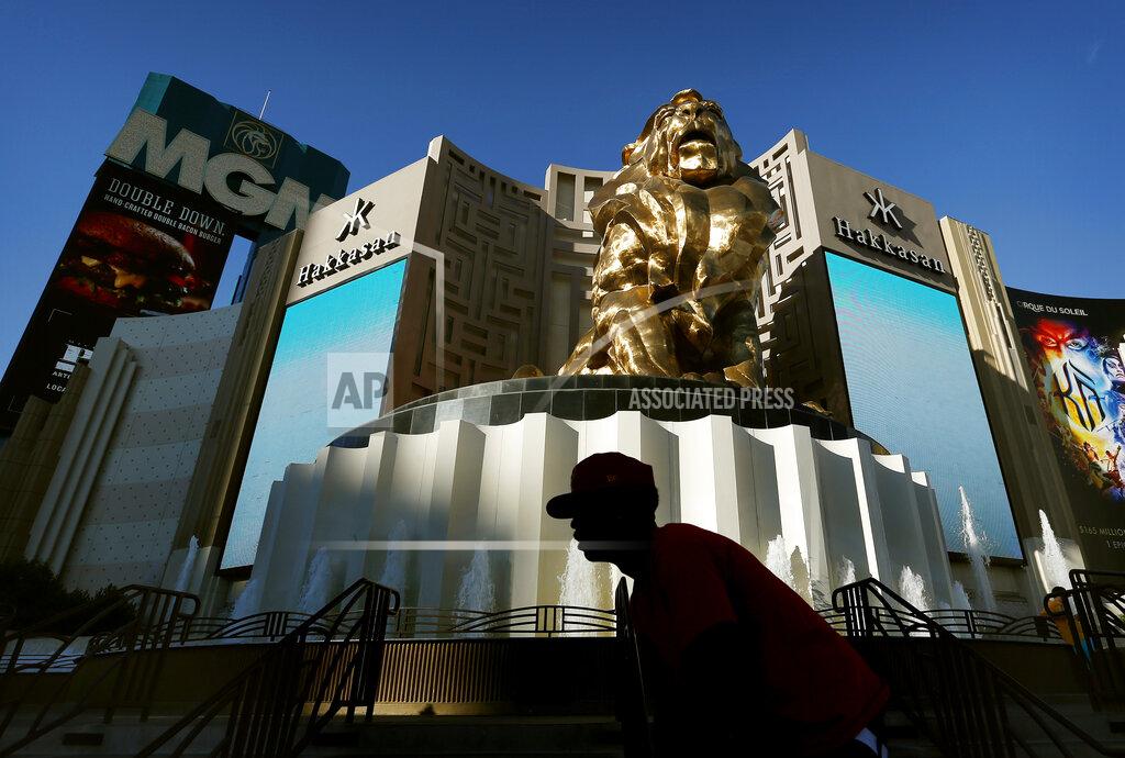 FILE - In this Aug. 3, 2015, file photo, a man rides his bike past the MGM Grand hotel and casino in Las Vegas. MGM Resorts International is selling the MGM Grand and Mandalay Bay resorts and casinos on the Las Vegas Strip to a joint venture for about $2.5 billion. (AP Photo/John Locher, File)