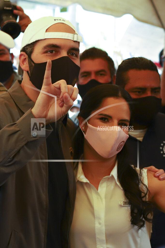 Salvador Melendez President Nayib Bukele holds up his marked finger after voting, as he poses with his wife Gabriela Rodriguez de Bukele at a polling station during local and legislative elections, in San Salvador, El Salvador, Sunday, Feb. 28, 2021. (AP Photo/Salvador Melendez)