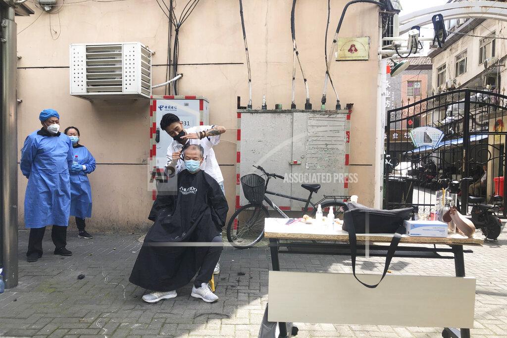 Chen Si A barber offering free haircuts for elderly residents serves a customer in Shanghai, China, Sunday, May 22, 2022. Numerous residential compounds in Beijing have restricted movement in and out, although conditions remain far less severe than in Shanghai, where millions of citizens have been under varying degrees of lockdown for two months. (AP Photo/Chen Si)