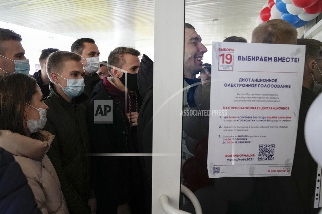 Pavel Golovkin People queue to cast their votes at the entrance of a polling station during parliamentary elections in Moscow, Russia, Friday, Sept. 17, 2021. Russia has begun three days of voting for a new parliament that is unlikely to change the country's political complexion. There's no expectation that United Russia, the party devoted to President Vladimir Putin, will lose its dominance in the State Duma. (AP Photo/Pavel Golovkin)