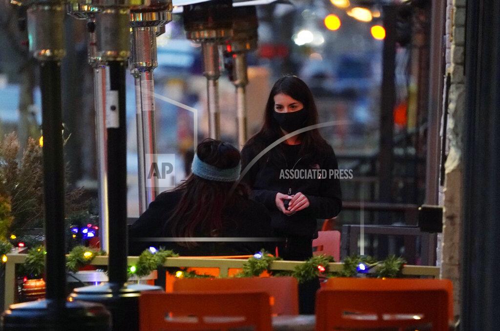 David Zalubowski FILE - In this Monday, Dec. 28, 2020, file photo, a server wears a face mask while tending to a patron sitting in the outdoor patio of a sushi restaurant, in downtown Denver. Restaurants devastated by the coronavirus outbreak are getting a lifeline from the pandemic relief package awaiting final approval in the House. (AP Photo/David Zalubowski, File)