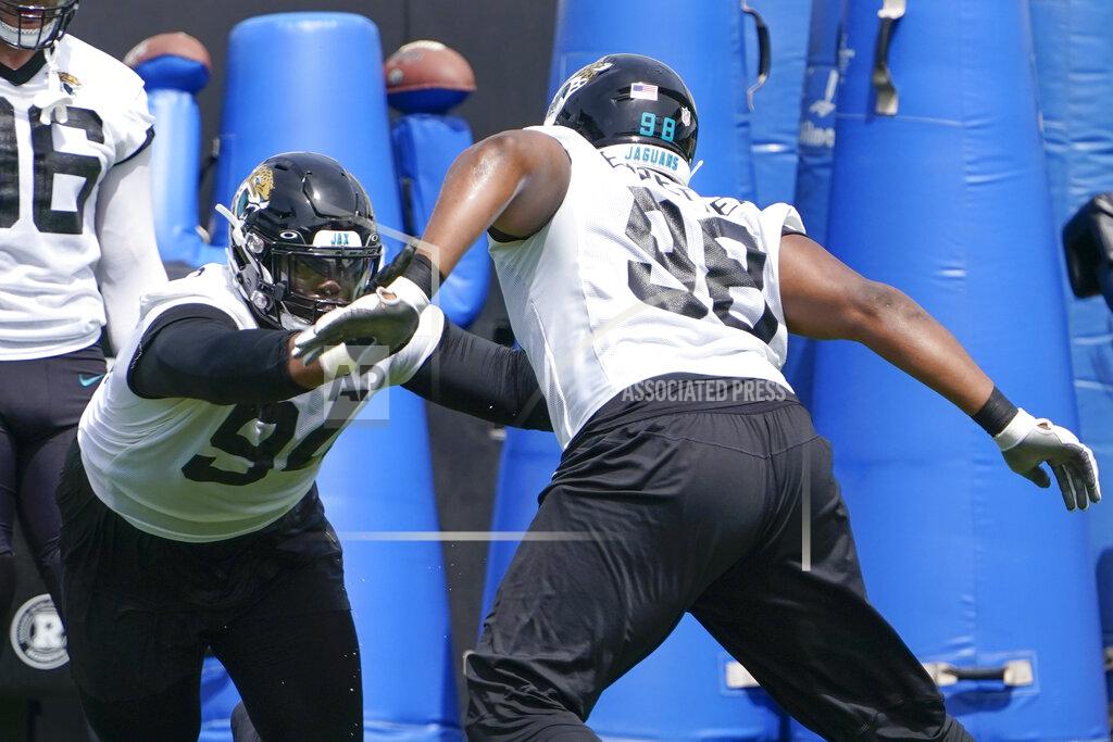John Raoux Jacksonville Jaguars defensive tackle Folorunso Fatukasi, left, performs a drill with defensive end Jeremiah Ledbetter (98) in an NFL football practice, Monday, May 23, 2022, in Jacksonville, Fla. (AP Photo/John Raoux)