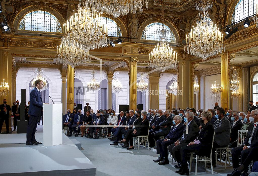 Gonzalo Fuentes French President Emmanuel Macron delivers a speech during a meeting in memory of the Algerians who fought alongside French colonial forces in Algeria's war, known as Harkis, at the Elysee Palace in Paris, Thursday, Sept. 20, 2021. Macron's speech is the latest step in his efforts to reconcile France with its dark colonial past, especially in Algeria. (Gonzalo Fuentes/Pool Photo via AP)