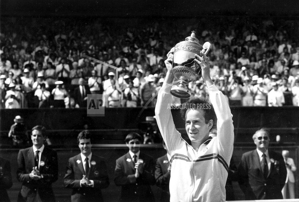Dave Caulkin FILE - In this July 8, 1984, file photo, John McEnroe, of the United States, lifts the trophy after defeating fellow American Jimmy Connors, 6-1, 6-1, 6-2, in the men's singles final on Wimbledon's center court. (AP Photo/Dave Caulkin, File)