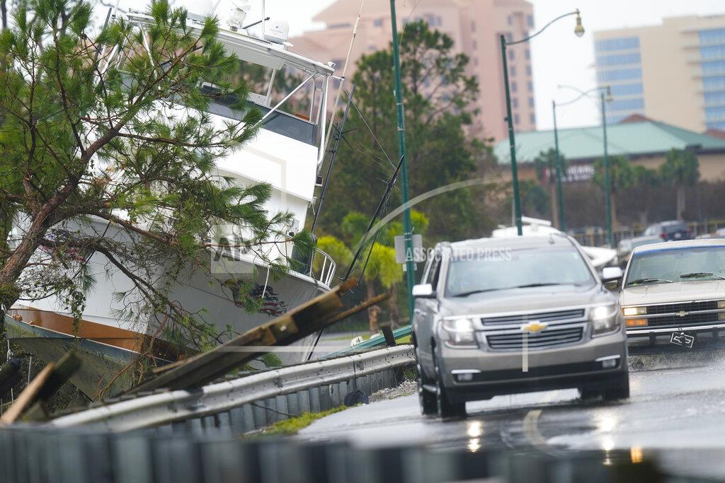 Gerald Herbert File - In this Sept. 16, 2020 file photo, vehicles maneuver on a flooded road near a boat washed up near the road after Hurricane Sally moved through the area, in Orange Beach, Ala. Hurricane Sally made landfall Wednesday near Gulf Shores, Alabama, as a Category 2 storm, pushing a surge of ocean water onto the coast and dumping torrential rain that forecasters said would cause dangerous flooding from the Florida Panhandle to Mississippi and well inland in the days ahead. (AP Photo/Gerald Herbert, File)