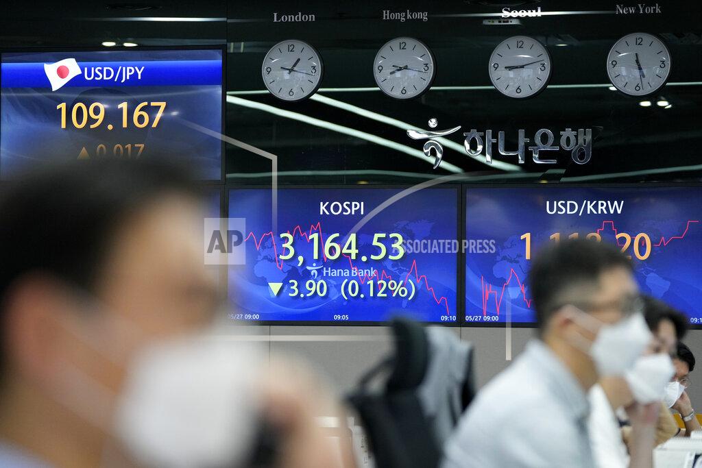 Lee Jin-Man Currency traders watch computer monitors near the screens showing the Korea Composite Stock Price Index (KOSPI), center, and the foreign exchange rates at the foreign exchange dealing room in Seoul, South Korea, Thursday, May 27, 2021. Asian shares fell Thursday, as investors watched for signs of inflation and awaited U.S. economic data expected later in the day. (AP Photo/Lee Jin-man)