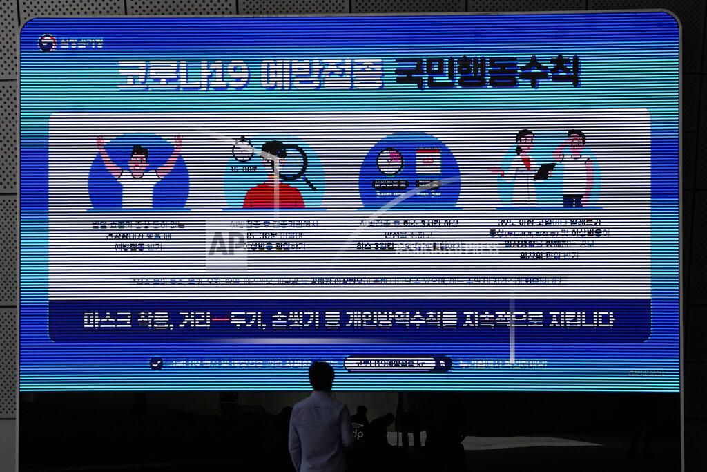 Lee Jin-Man A man wearing a face mask looks at a screen displaying precautions against the coronavirus in Seoul, South Korea, Monday, May 24, 2021. The letters read "Keep social distancing and mandatory mask wearing as a prevent the spread of the coronavirus." (AP Photo/Lee Jin-man)