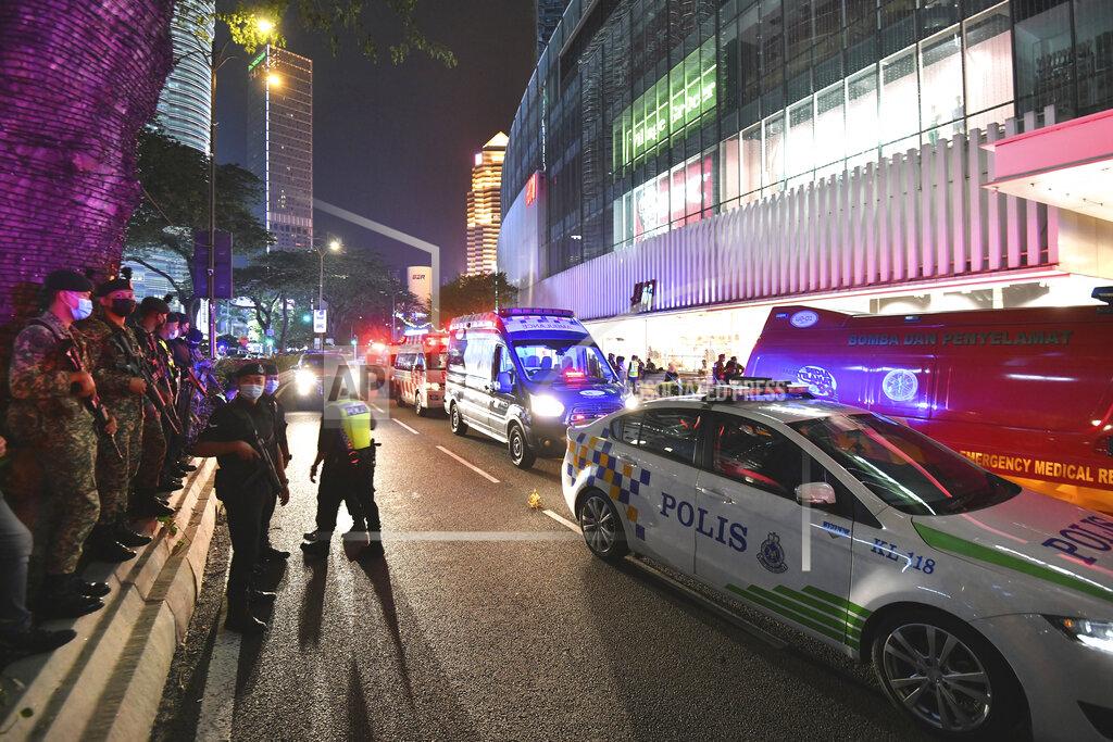 Uncredited Fire and rescue personnel gather outside a shopping mall to help injured passengers at KLCC station after two trains of Kuala Lumpur Light Rail Transit (LRT) collided in Kuala Lumpur, Malaysia, Monday, May 24, 2021. (AP Photo)