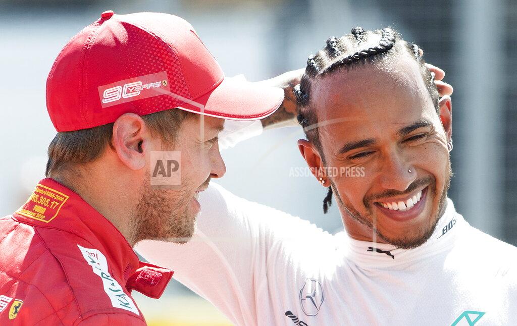 Graham Hughes Ferrari driver Sebastian Vettel of Germany, left, talks with Mercedes driver Lewis Hamilton of Great Britain after winning pole position during qualifying for the Formula One Canadian Grand Prix auto race in Montreal, Saturday, June 8, 2019. (Graham Hughes/The Canadian Press via AP)