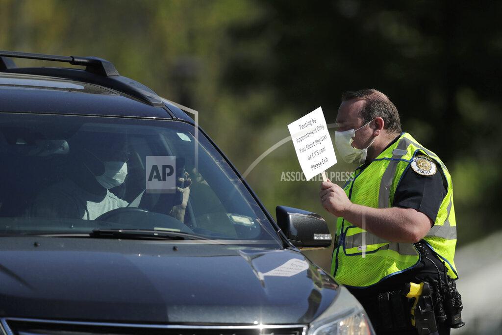 Brynn Anderson A person holds up their phone to show an official an appointment confirmation at a COVID-19 testing site on Georgia Tech's campus, Monday, April 6, 2020, in Atlanta. (AP Photo/Brynn Anderson)
