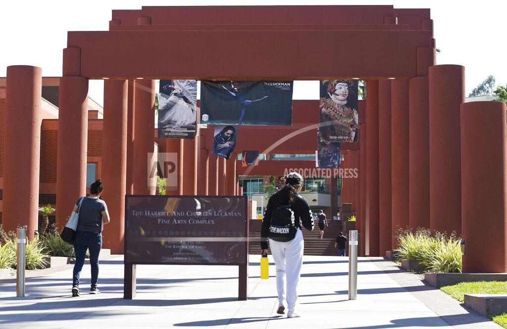 Damian Dovarganes FILE - In this April 25, 2019, photo students walk past the Harriet and Charles Luckman Fine Arts Complex at the Cal State University, Los Angeles campus. The Federal Emergency Management Agency plans to end its mass vaccination pilot programs in Oakland and Cal State LA campus in Los Angeles next month. Officials said Friday, March 26, 2021, that the vaccine sites have provided nearly a half-million doses so far. (AP Photo/Damian Dovarganes, File)