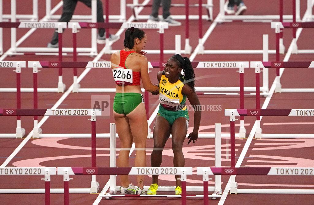 Charlie Riedel Luca Kozak, of Hungary, left, helps Yanique Thompson, of Jamaica, center, to her feet after both failed to finish a women's 100-meter hurdles semifinal at the 2020 Summer Olympics, Sunday, Aug. 1, 2021, in Tokyo, Japan. (AP Photo/Charlie Riedel)