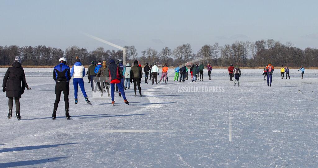 Peter Dejong People skate on Nannewiid Lake in Oudehaske, Netherlands, Friday, Feb. 12, 2021. With many lakes and canals in the Netherlands frozen over, Dutch skating fans flocked to the ice Friday, causing a headache for authorities trying to enforce social distancing measures to stop the spread of the coronavirus. (AP Photo/Peter Dejong)