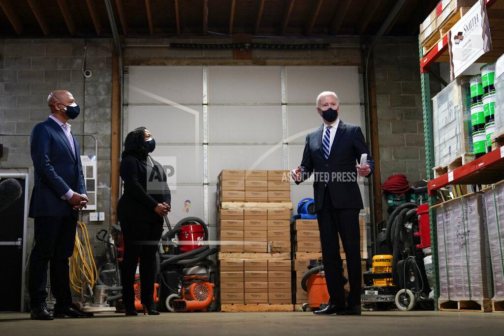 Carolyn Kaster President Joe Biden speaks with owners Kristin Smith and James Smith as he visits Smith Flooring in Chester, Pa., Tuesday, March 16, 2021. (AP Photo/Carolyn Kaster)