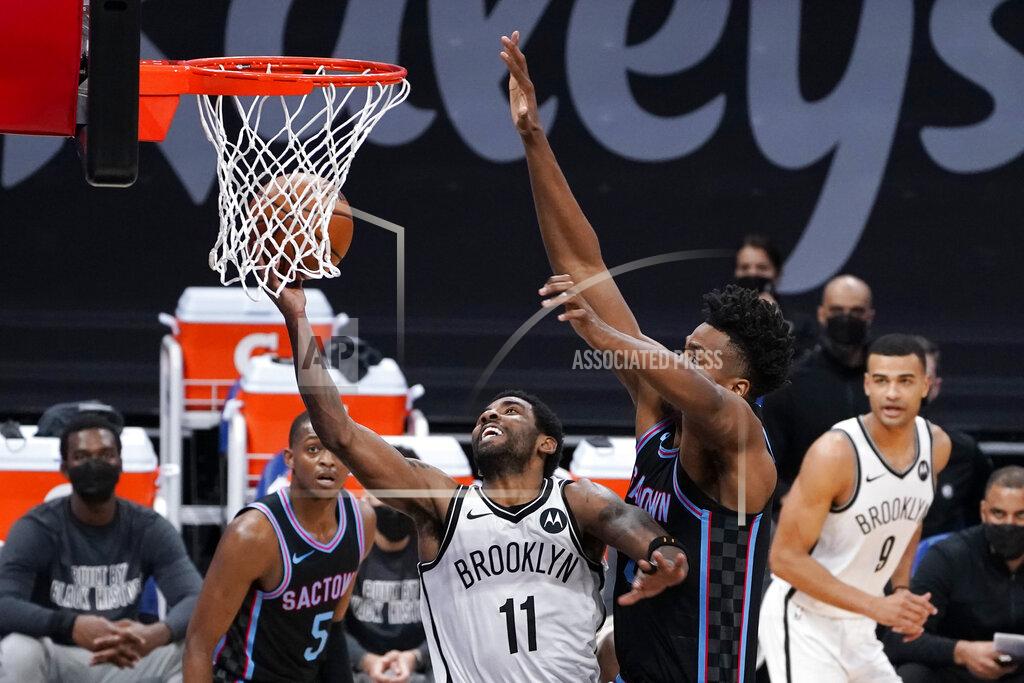 Rich Pedroncelli Brooklyn Nets guard Kyrie Irving (11) goes to the basket against Sacramento Kings center Hassan Whiteside, front right, during the first half of an NBA basketball game in Sacramento, Calif., Monday, Feb. 15, 2021. (AP Photo/Rich Pedroncelli)