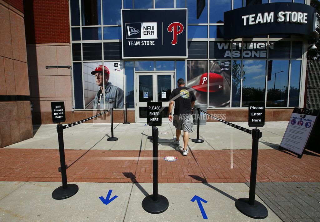 Yong Kim A person walks toward the Philadelphia Phillies team store at Citizens Bank Park on Monday, July 27, 2020, in Philadelphia. The Phillies' game against the New York Yankees on Monday was postponed after several members of the Miami Marlins tested positive for the coronavirus. (Yong Kim/The Philadelphia Inquirer via AP)